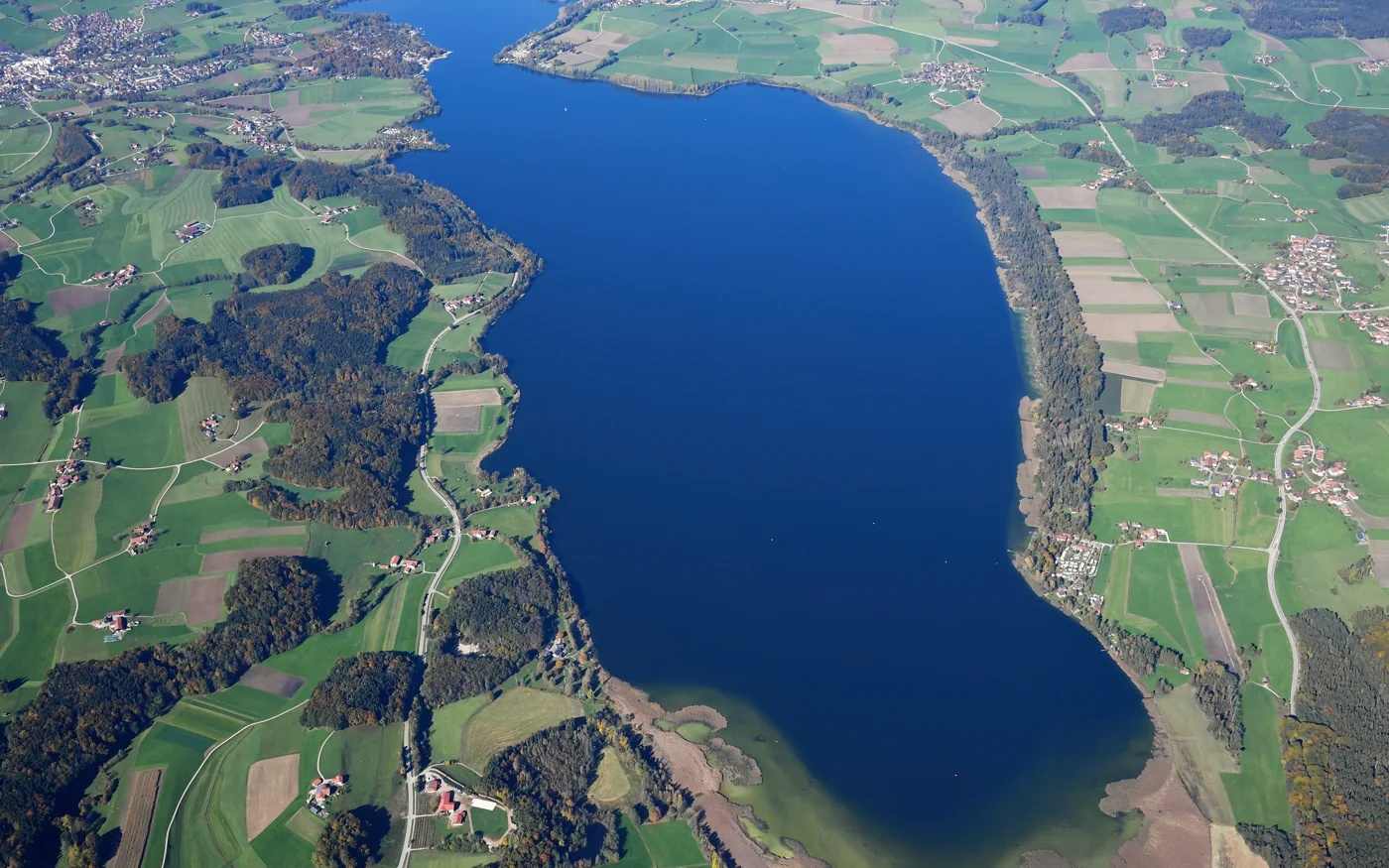 Luftbild des Waginger Sees mit dunkelblauer Wasserfläche, grünen Ufern und Ortschaften