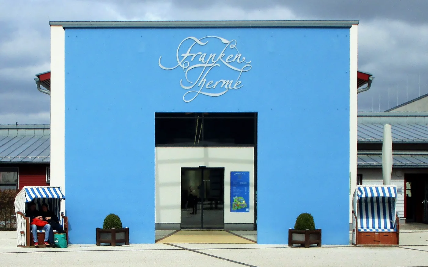 Blaues Eingangsportal der Franken-Therme Bad Windsheim mit Schriftzug und zwei Strandkörben