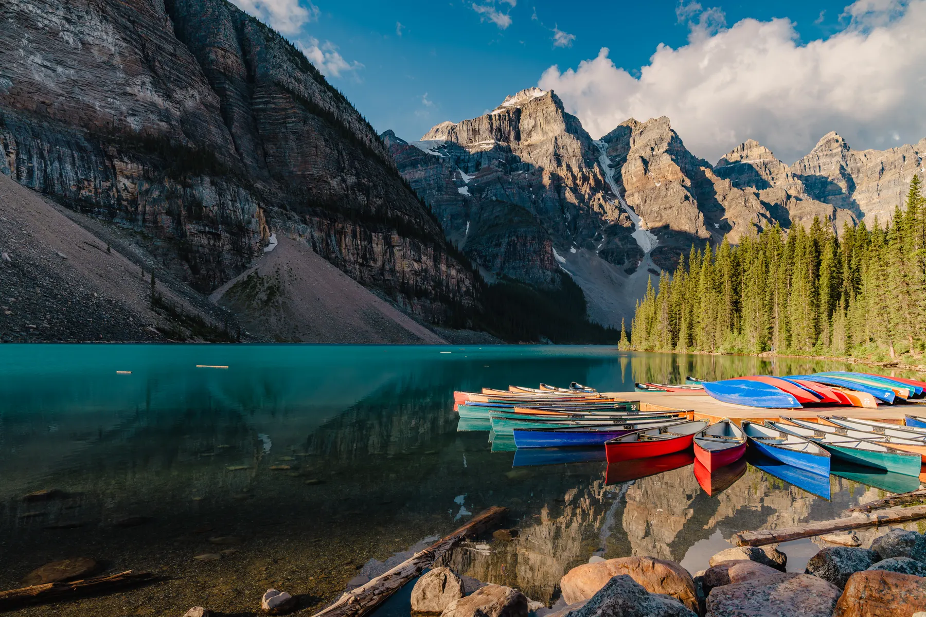 Bunte Kajaks an einem türkisblauen Bergsee
