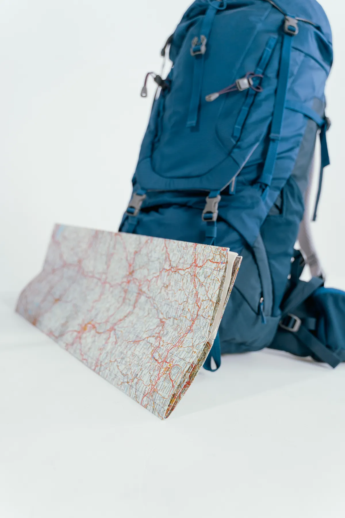 Blauer Rucksack neben einer aufgefalteten Karte